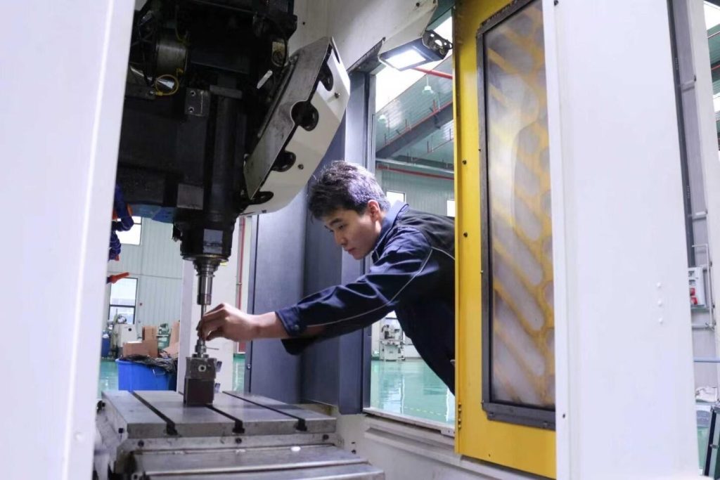 YXT CNC machine shop - operator setting up a CNC machining center