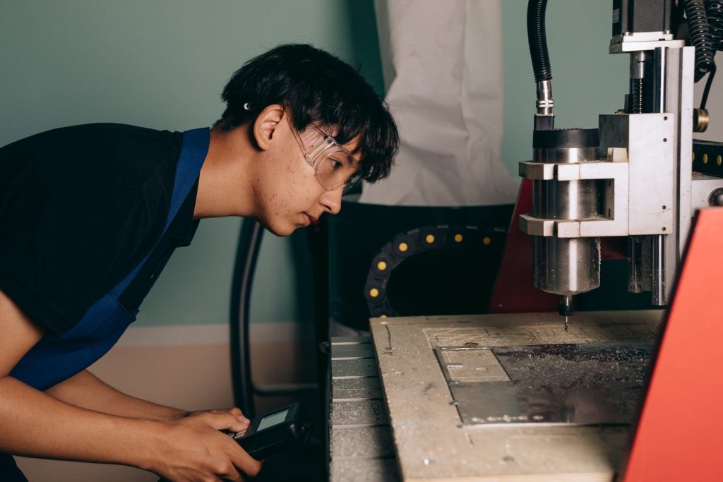 Engineer inspecting a CNC machining process at the machine