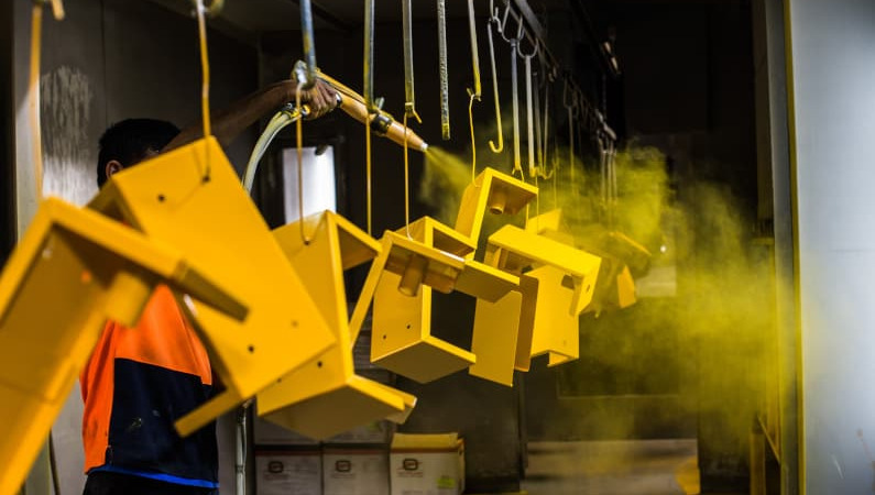Powder coated metal parts moving through a production line